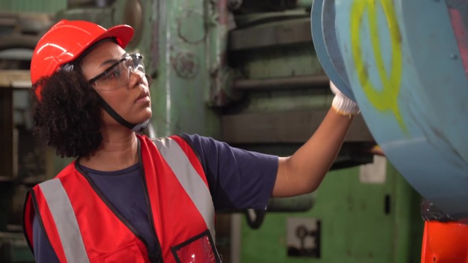 非裔美国机械工程师，在金属重型工厂从事监控工作。黑人女工在仓库车间控制机器