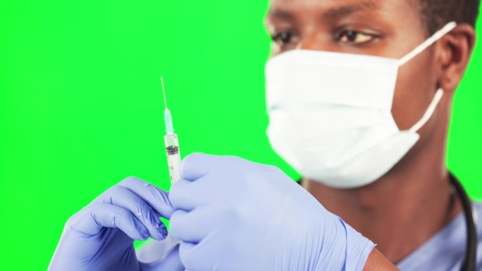 新冠病毒、疫苗和拿着针的医生在绿屏工作室里提供医疗保健、帮助和治疗。注射器、免疫和非洲男性疾病、预防