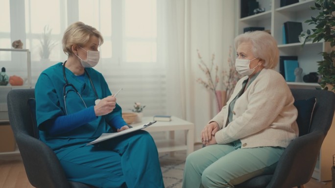 医生带着口罩上门探望生病的老年妇女，治疗病毒性疾病