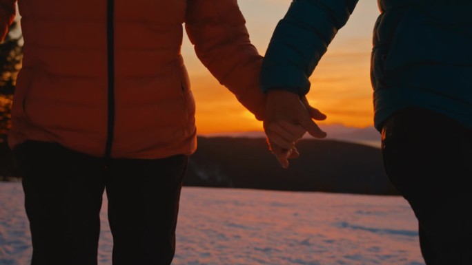 一对陌生的情侣在黄金时间漫步在雪地里，享受着深情的时刻