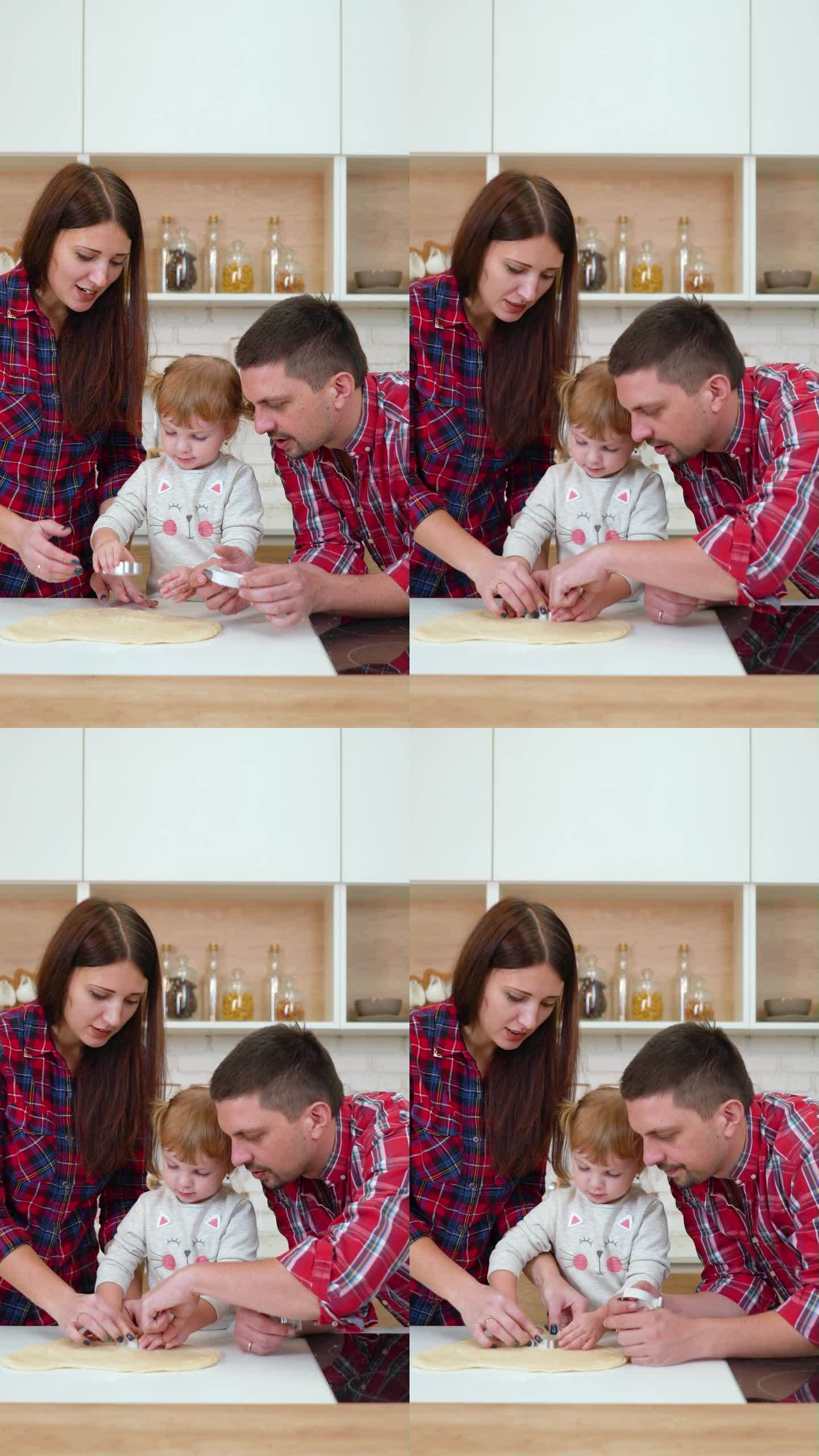 竖屏:小女孩和她的父母在切饼干