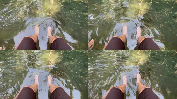 印度尼西亚，一名男子在河中泡脚。放松旅行b卷概念