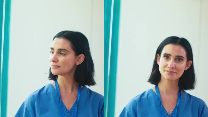 成熟女医生的垂直视频肖像在医院里穿着手术服和数字平板电脑