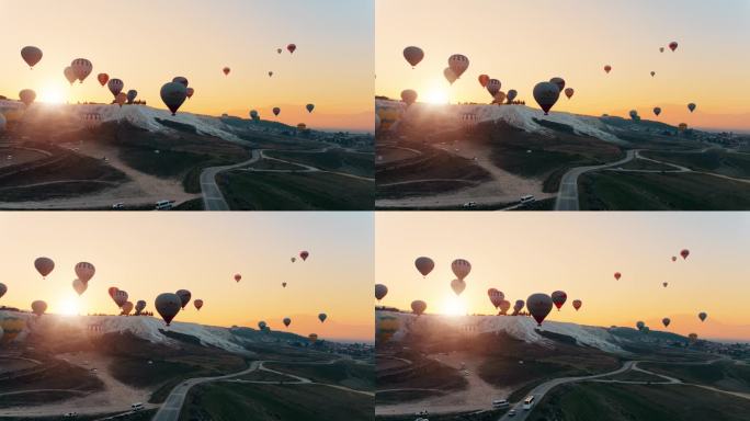 热气球飞过Pamukkale山谷，映衬着群山和忧郁的天空。航拍无人机视频