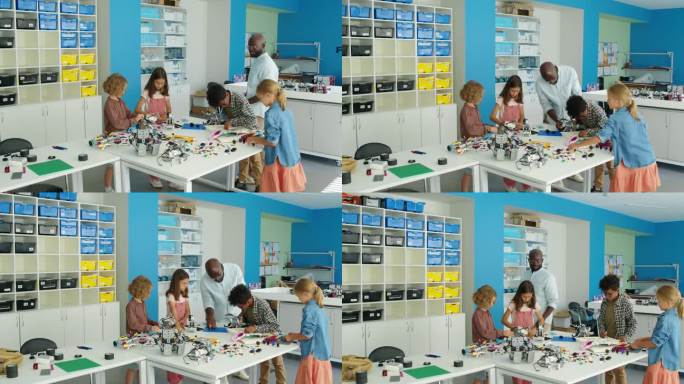 不同的孩子制作机器人模型和黑人男老师观看