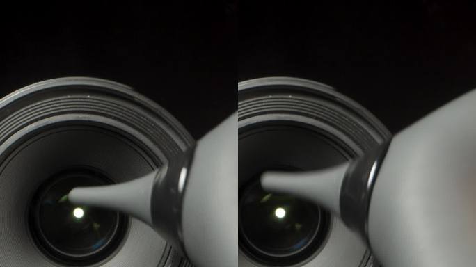 镜头从一个黑色背景的数码相机，我吹灰尘从它与橡胶球气泵垂直视频。