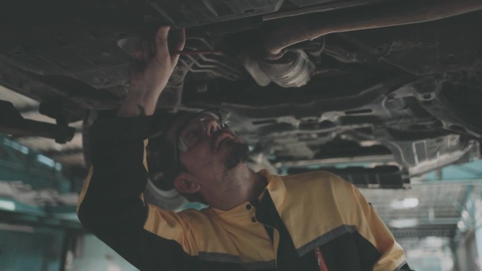 保险人员检查汽车以评估修理汽车的费用。