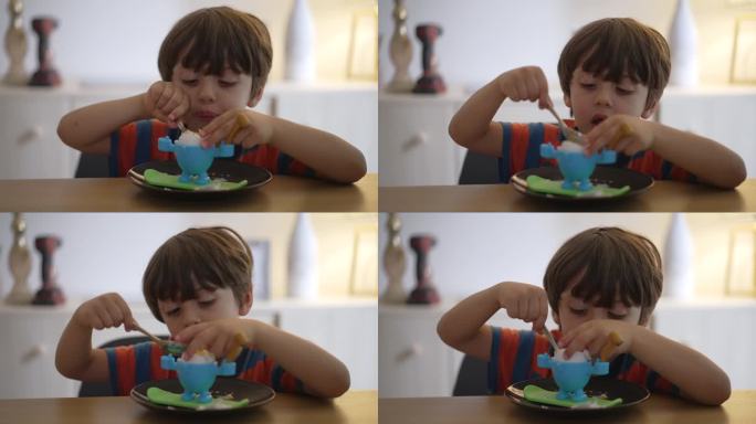 一个小男孩在吃煮熟的鸡蛋，但没有煮熟。孩子自己用勺子吃便餐