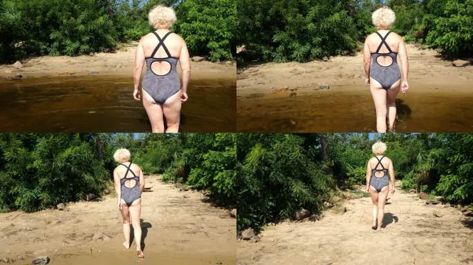 后视图一个六十岁的金发女人穿着泳衣走在水面上的海滩在丛林