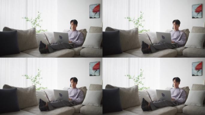 韩国男性在家工作，使用他的笔记本电脑优化性能和实现目标，创建引人入胜的内容和管理社交媒体活动