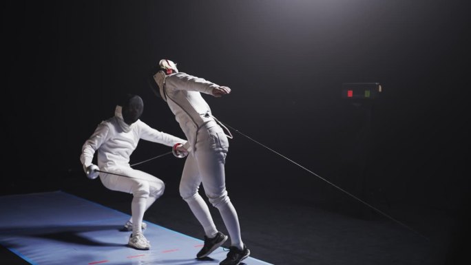 后视图两名职业击剑运动员在比赛中全副防护装备碰撞花剑。低空俯冲，命中