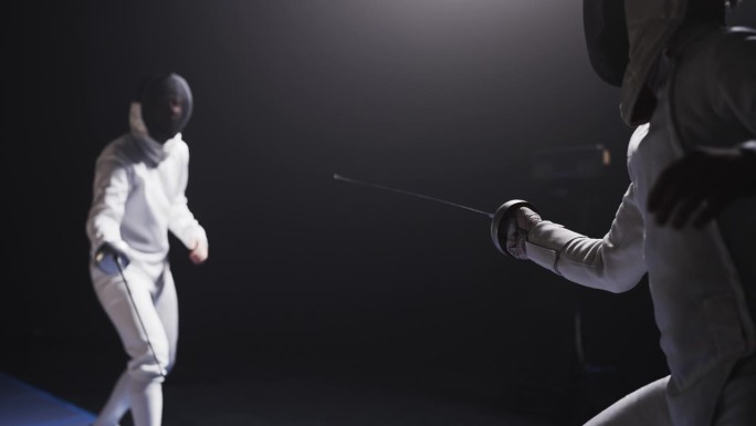 后视图两名职业击剑运动员在比赛中全副防护装备碰撞花剑。取得成功