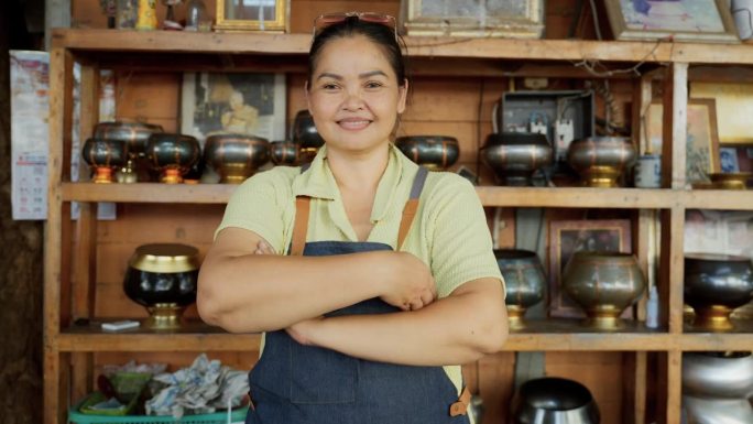 亚洲街头小吃女厨师看着镜头。成功的小企业主。