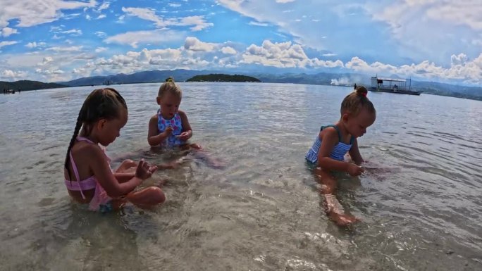 三姐妹的孩子们在海滩和浅水里玩耍