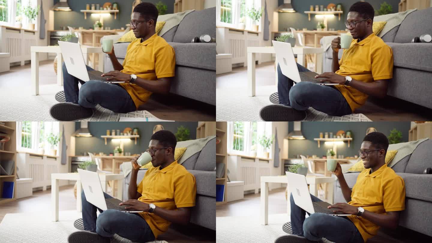 非裔美国人一边喝咖啡，一边在家用笔记本电脑工作