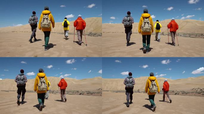 一组四名旅行者一起沿着荒野地区向前走沙漠