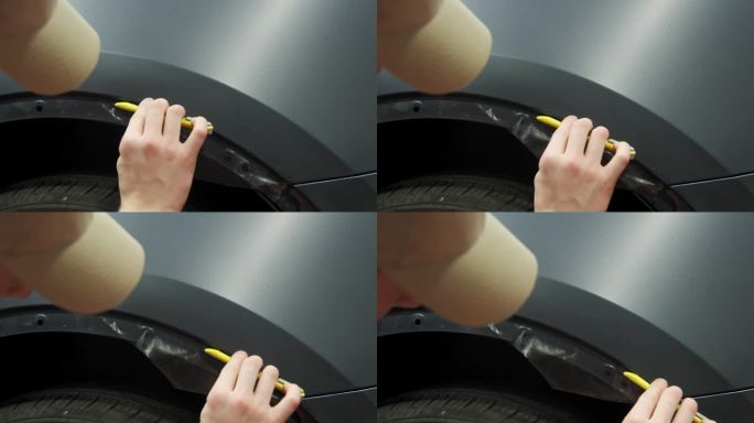 将PPF保护膜涂在汽车上的过程。工人正在给一辆黑色轿车涂保护膜。特写镜头