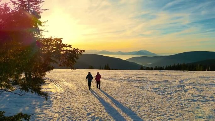 两个无法辨认的徒步旅行者在雪地里行走。