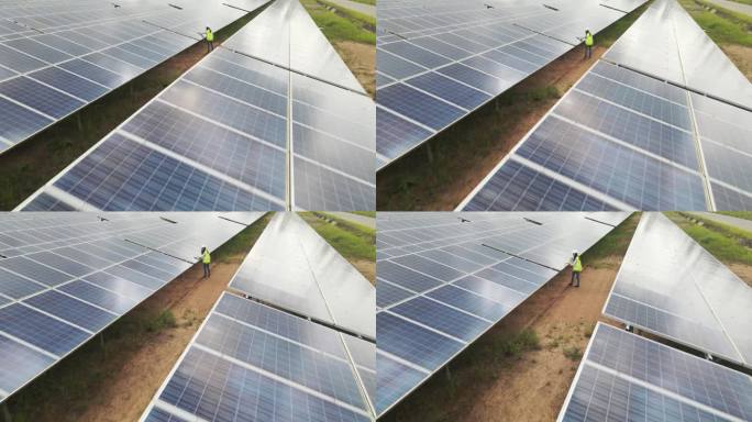 无人机拍摄的两名太阳能工程师在太阳能农场工作。