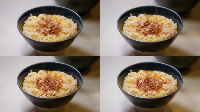 鸡蛋煮米饭，上面放着鲣鱼片。放酱油的视频。