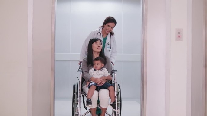 女儿科医生在检查后用轮椅移动病人。