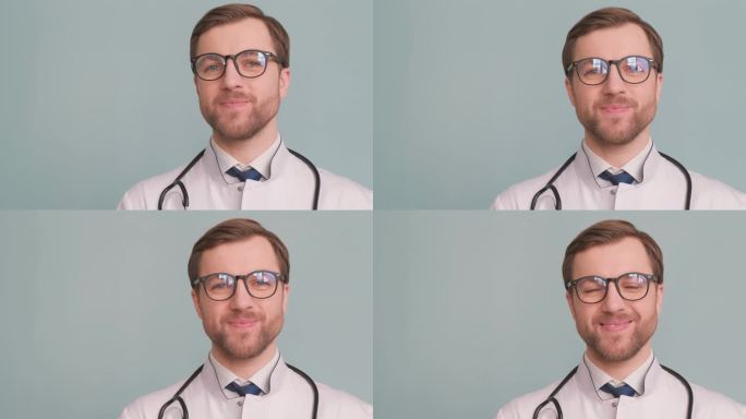 年轻迷人的大胡子医生的特写肖像，戴着蓝色背景的眼镜，微笑着。