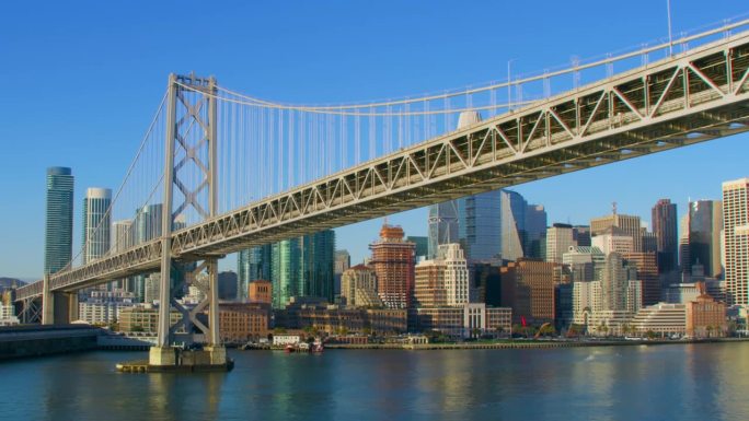 在旧金山奥克兰海湾大桥下飞行。美国加州。与交通。背景是金融区。用红色武器8K射击。