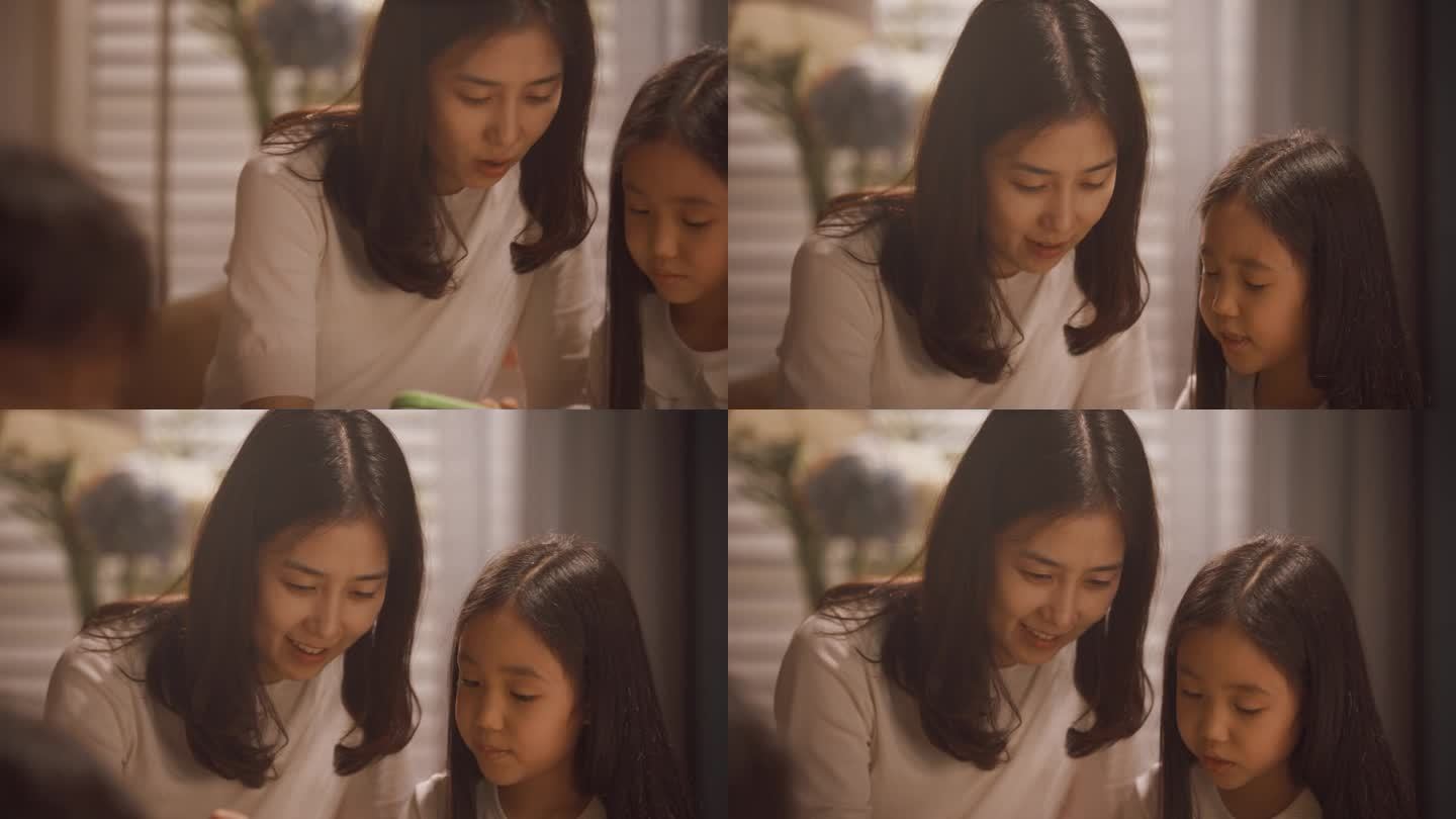 一位英俊的韩国父亲在儿童房与孩子们玩耍的肖像。焦点切换到一个美丽的母亲和年幼的女儿在平板电脑上玩教育