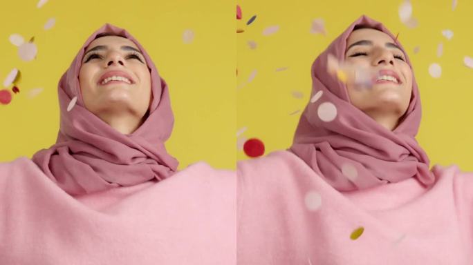 快乐的穆斯林妇女被空中飞舞的彩纸包围