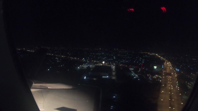 从飞机的窗户看到夜晚城市的灯光