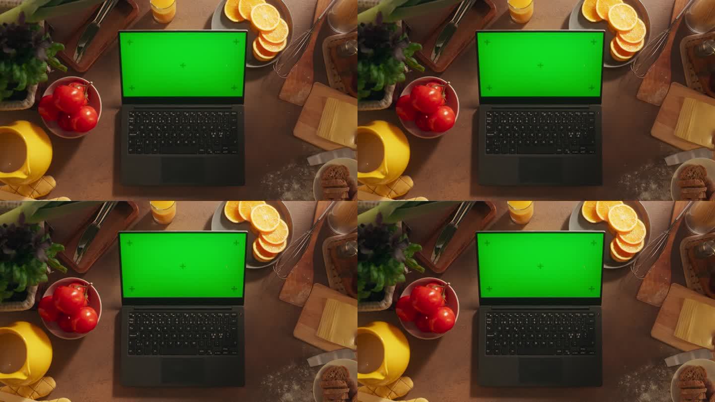 一台笔记本电脑的顶部静态视图与模拟绿屏Chromakey显示器站在一个健康的早餐厨房的桌子上，充满了