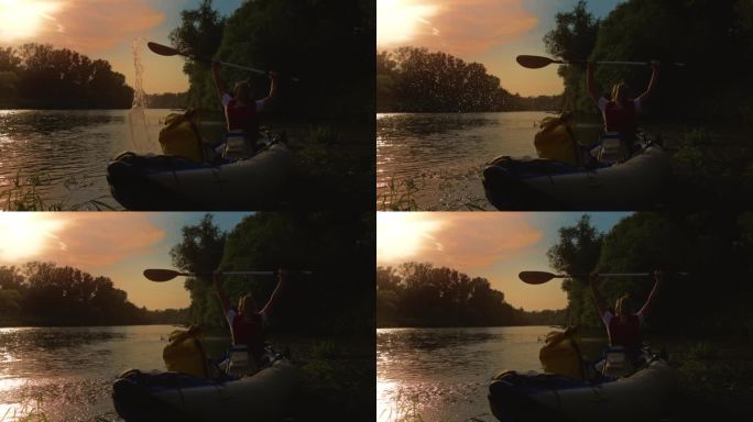 女子在田园诗般的河上划皮艇，举起双臂