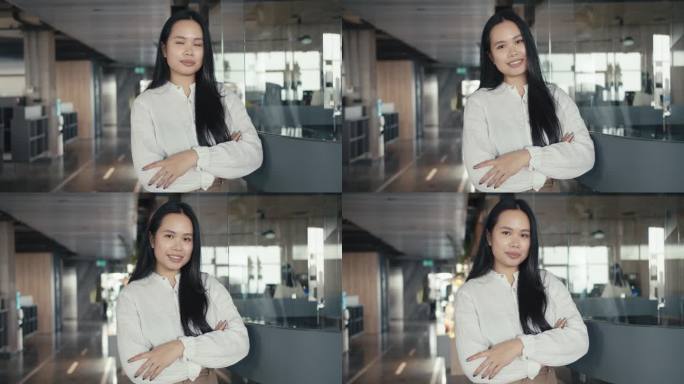 自信的亚洲女孩穿着白衬衫在办公室的背景下摆姿势。成功之道