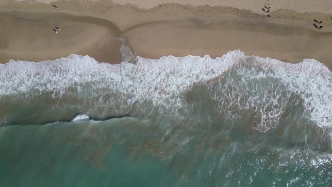 鸟瞰透明的蓝色大海，在夏天阳光明媚的日子里有美丽的海浪。热带景观从空气的海洋与蔚蓝的水，在日落沙底。