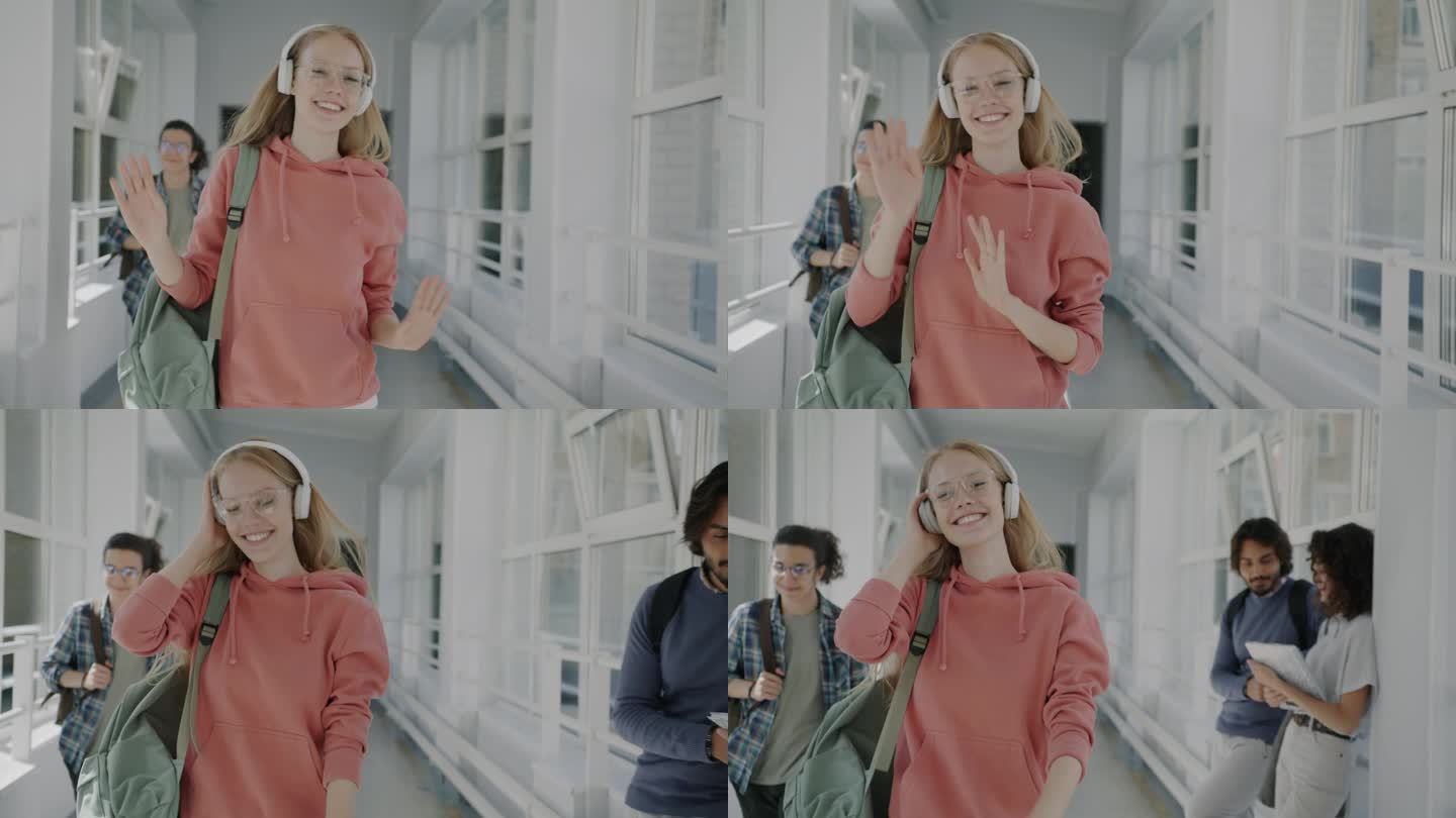 多莉拍摄的快乐的年轻金发女郎戴着耳机走在大学大厅跳舞，听音乐的乐趣