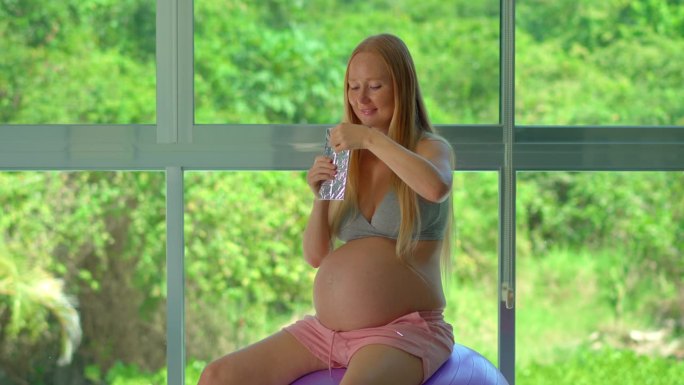 在这个慢动作视频中，一位孕妇沉迷于巧克力棒，探索怀孕期间偶尔放纵的概念。该视频强调了渴望和平衡营养的
