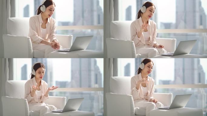 亚洲女商人出差时，在酒店或市中心办公室的沙发上使用科技笔记本电脑工作和视频会议的肖像