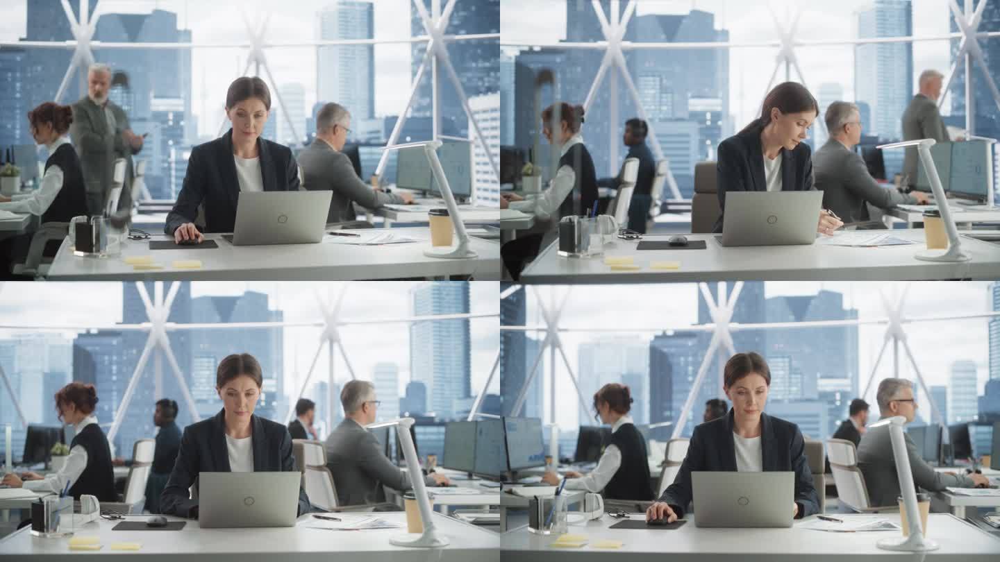 在市中心明亮的摩天大楼办公室里，职业女性业务发展经理在笔记本电脑上打字。成功的白人女性在多样化的工作