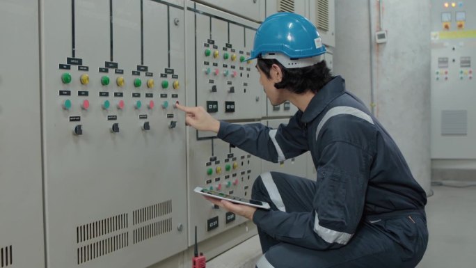 一名电工工程师在工业工厂的控制室、操作站网络中检查和记录电气保护继电器参数。