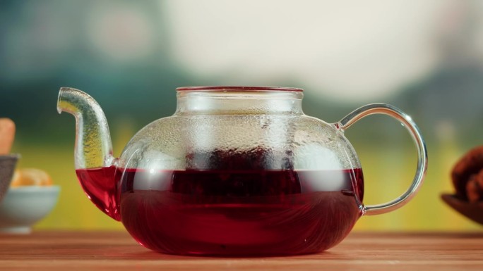 木桌上的红果茶茶壶。现泡木槿茶道工艺，健康早晨，排毒饮品。