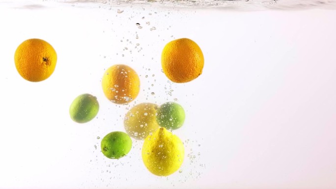 柑橘繁荣。青柠、柠檬和橙子落入水中。点心
