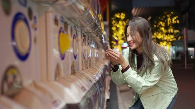 日本东京，一名4K亚洲女子在夜间从充气娃娃自动贩卖机里拿着玩偶。