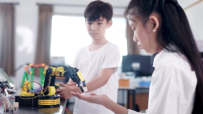 孩子们在课堂上练习编程来控制机器人。