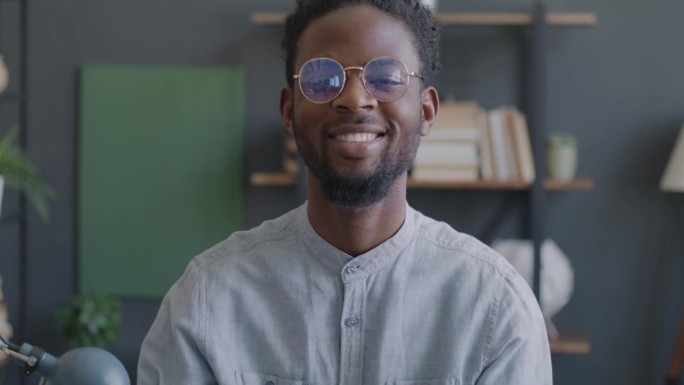 快乐的非裔美国企业家在工作场所看着镜头微笑的慢动作肖像