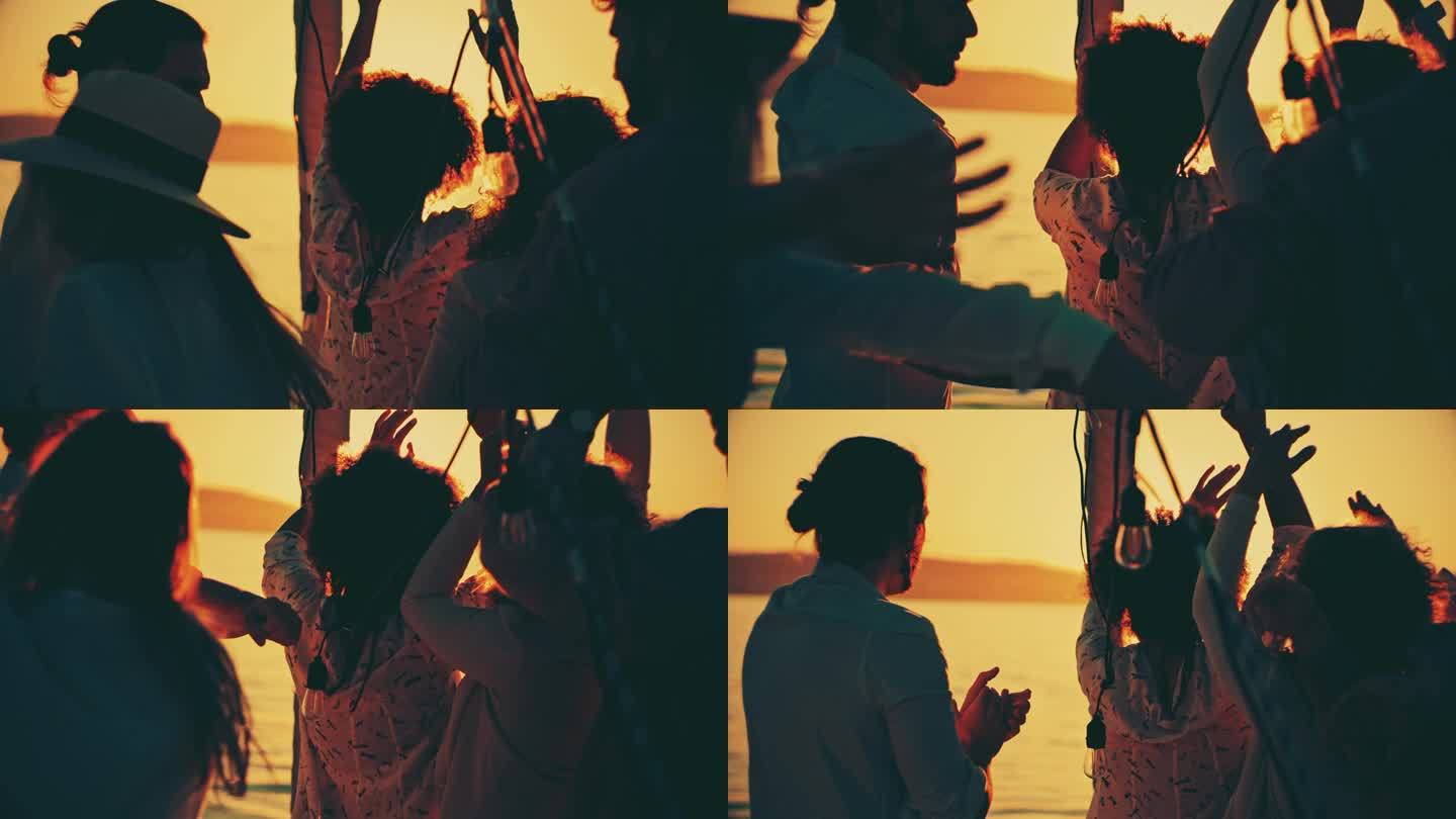 一群朋友在日落时分在船甲板上跳舞的慢镜头。