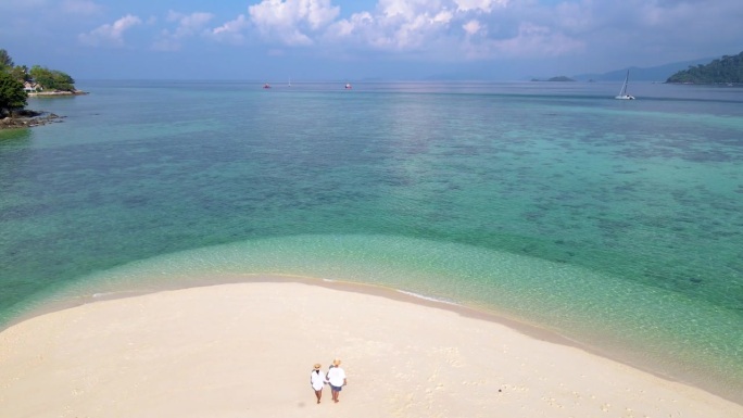 一对情侣在泰国利佩岛海滩上，这是一个有着蓝色海洋的热带岛屿