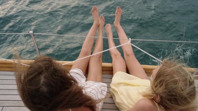 头顶女友的腿挂在海上的帆船上奢侈的生活方式快乐的冒险旅行度假