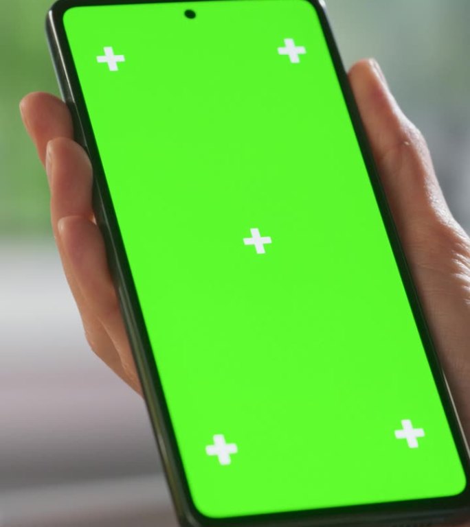 垂直屏幕:顶部视图匿名女性使用智能手机模拟绿屏Chromakey显示与运动跟踪占位符。女人在家里查看