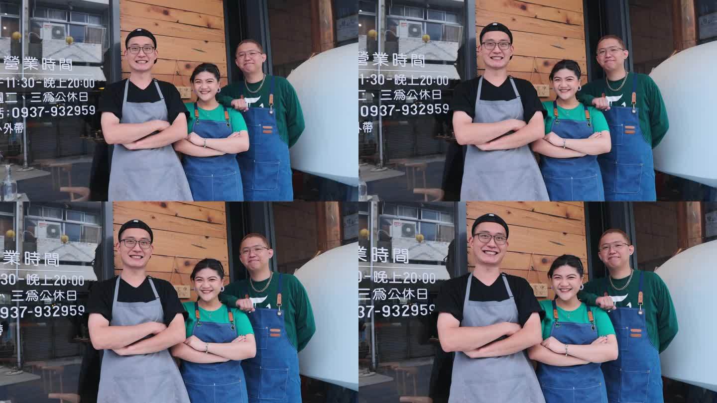 亚洲中餐馆老板和他的员工站在店前，微笑着看着镜头