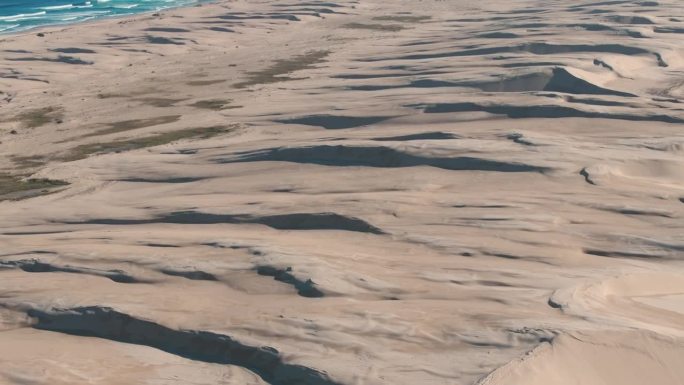 4K无人机鸟瞰美丽的自然海洋和沙漠在纽卡斯尔澳大利亚在阳光明媚的日子。